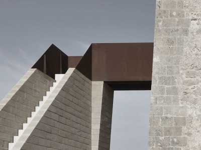 La scala, realizzata in pietra, � staccata dal corpo dell�edificio. A collegarla con la torre c'� un ponticello rossiccio di corten, tipologia di acciaio preossidato particolarmente resistente
